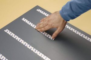 Fixation du miroir à l'aide du ruban de montage. 