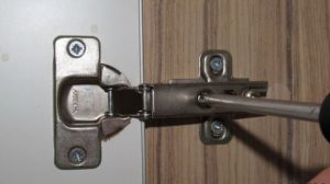 Réglage de la hauteur de la porte de l'armoire.