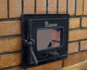 Installation de la porte de combustion d'un four en brique