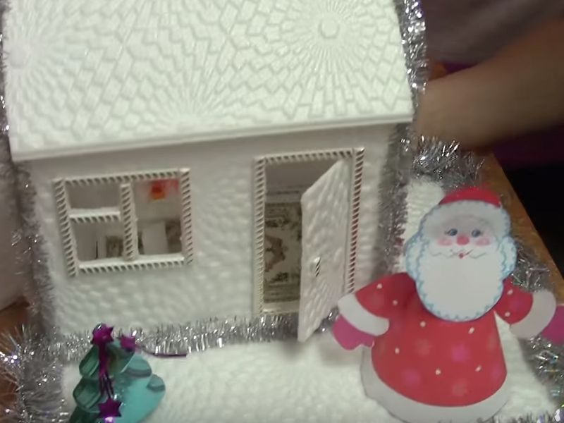 Nous plaçons un jouet du Père Noël près de la maison.