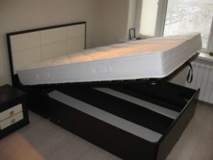 Lit avec mécanisme de levage.