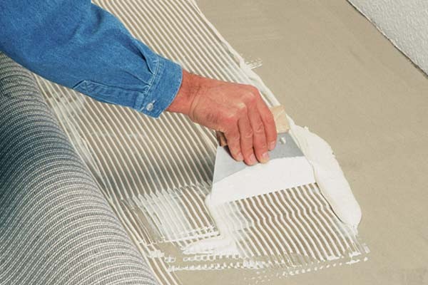 Pose de moquette avec de la colle.