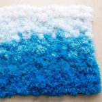 tapis à pompons bleu et blanc