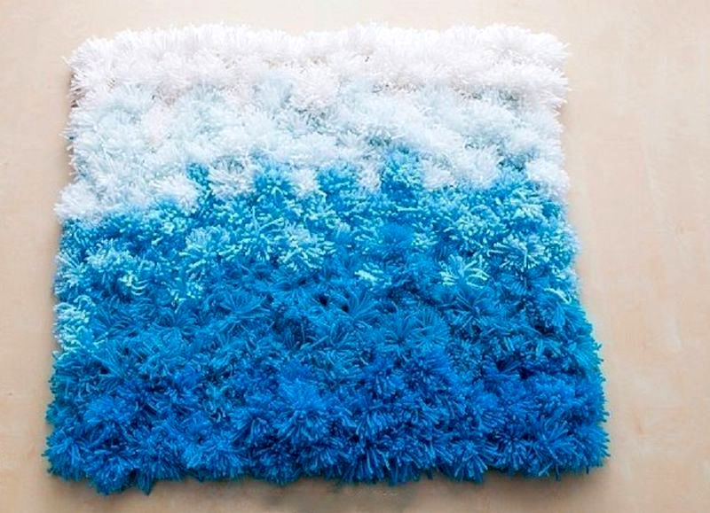 tapis à pompons bleu et blanc