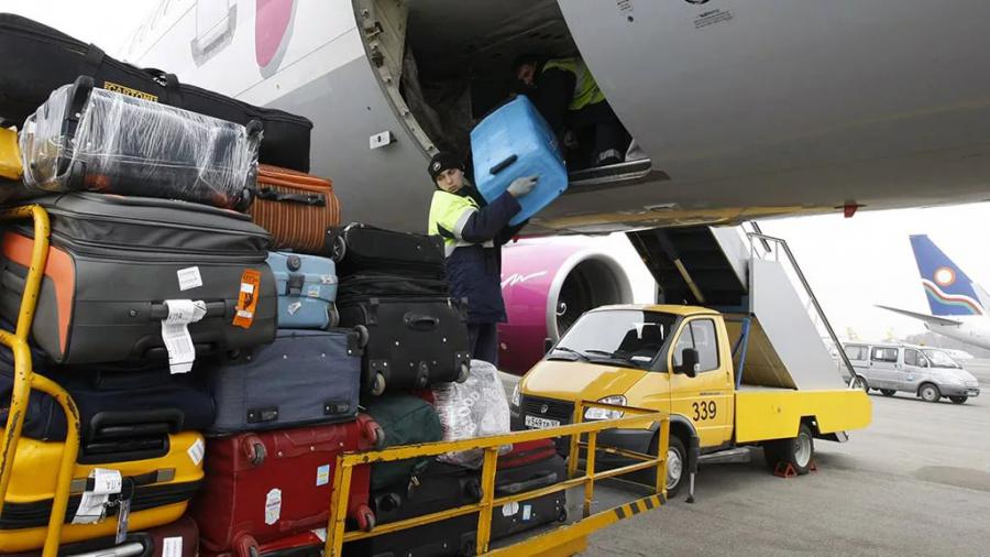 Chargement de bagages dans le compartiment à bagages d'un avion