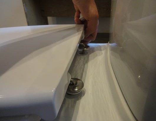 Nous fixons le siège des toilettes.