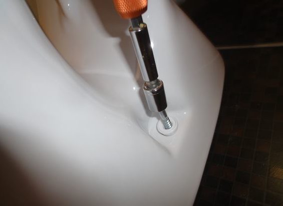 Nous installons les toilettes et resserrons les boulons.