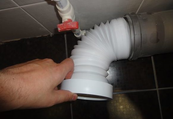 Nous insérons l'extrémité du tuyau dans l'égout.