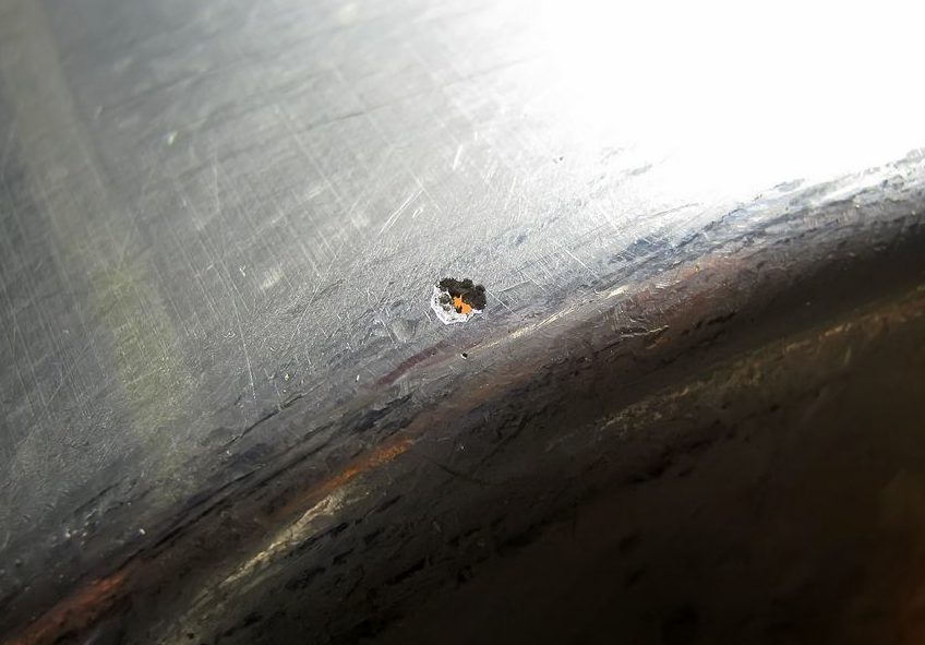 Trou dans une poêle en aluminium.