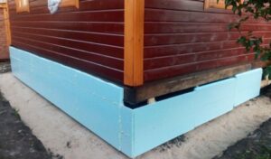 Isolation d'une fondation sur pieux d'une maison en bois par l'extérieur